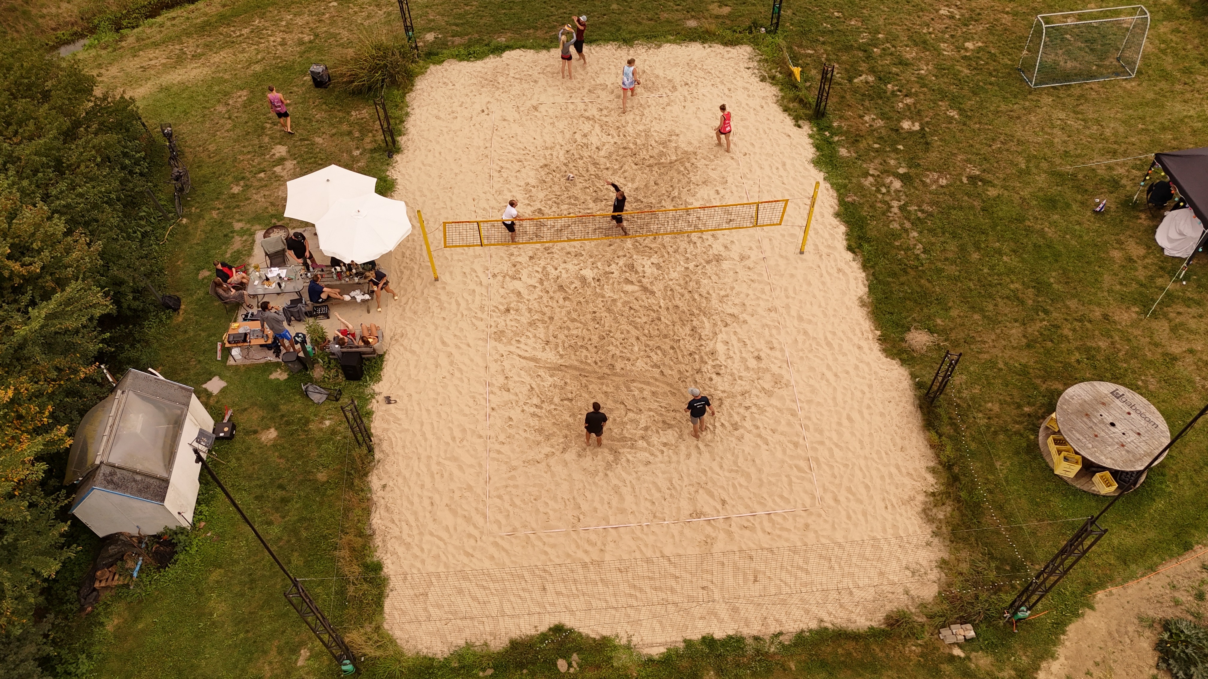 Große Luftaufnahme des Sandplatzes mit Spielbetrieb